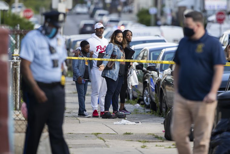 a stricken family looks on at a crime scene