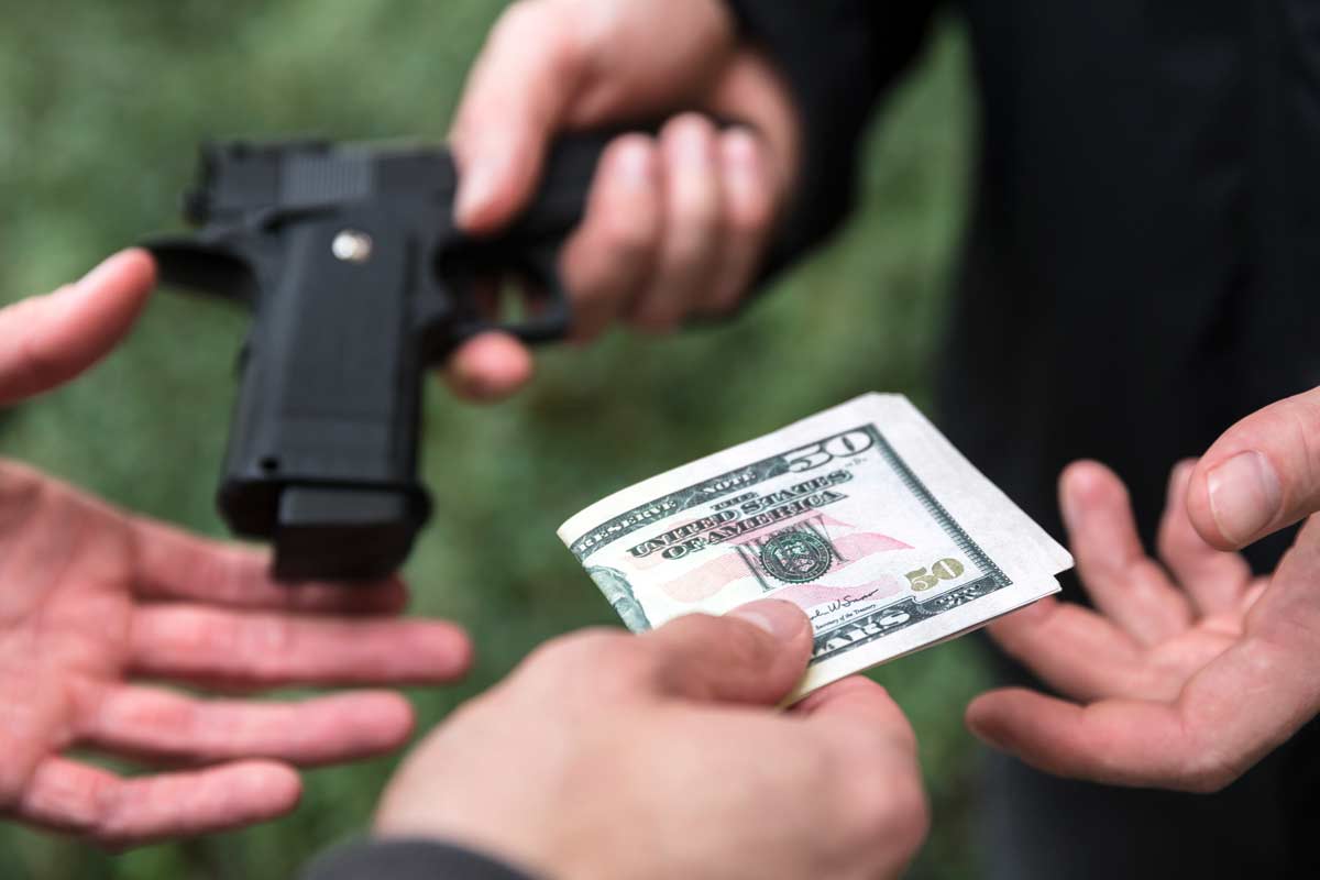hands exchanging money for a gun
