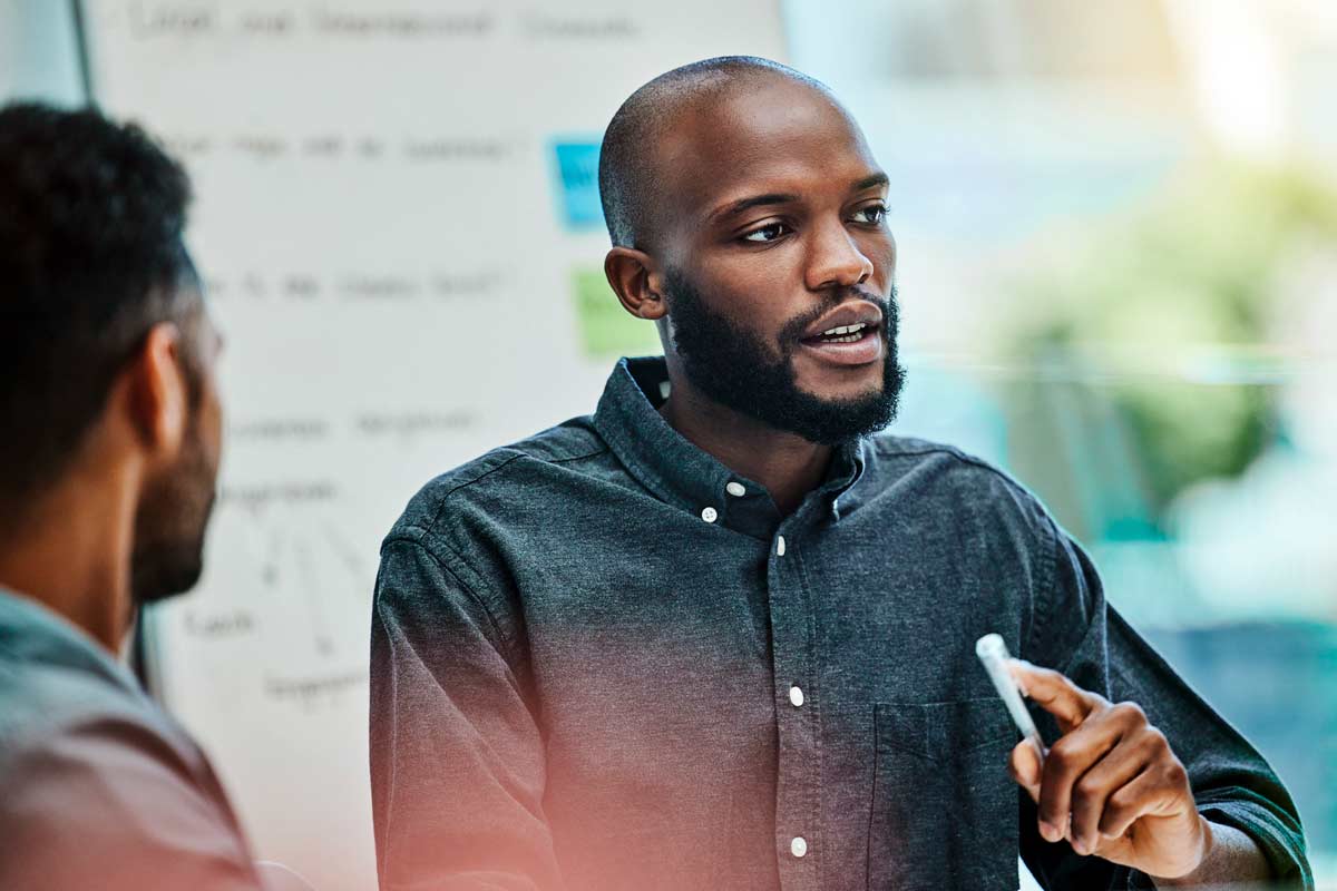 man instructing group at whiteboard