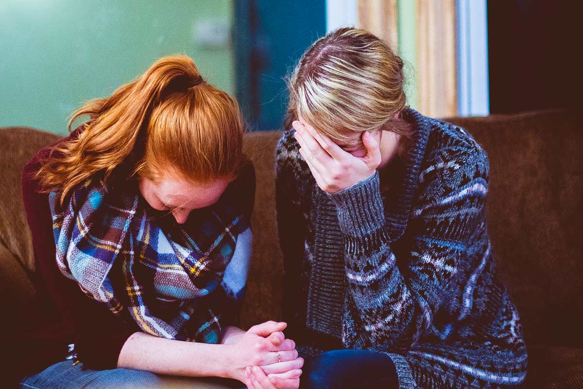 women crying and praying