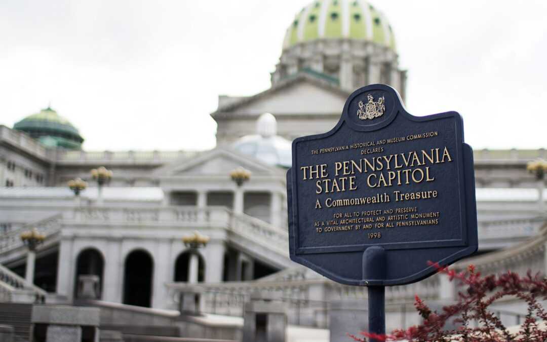 Photo of PA State Capitol building with blue sign in foreground